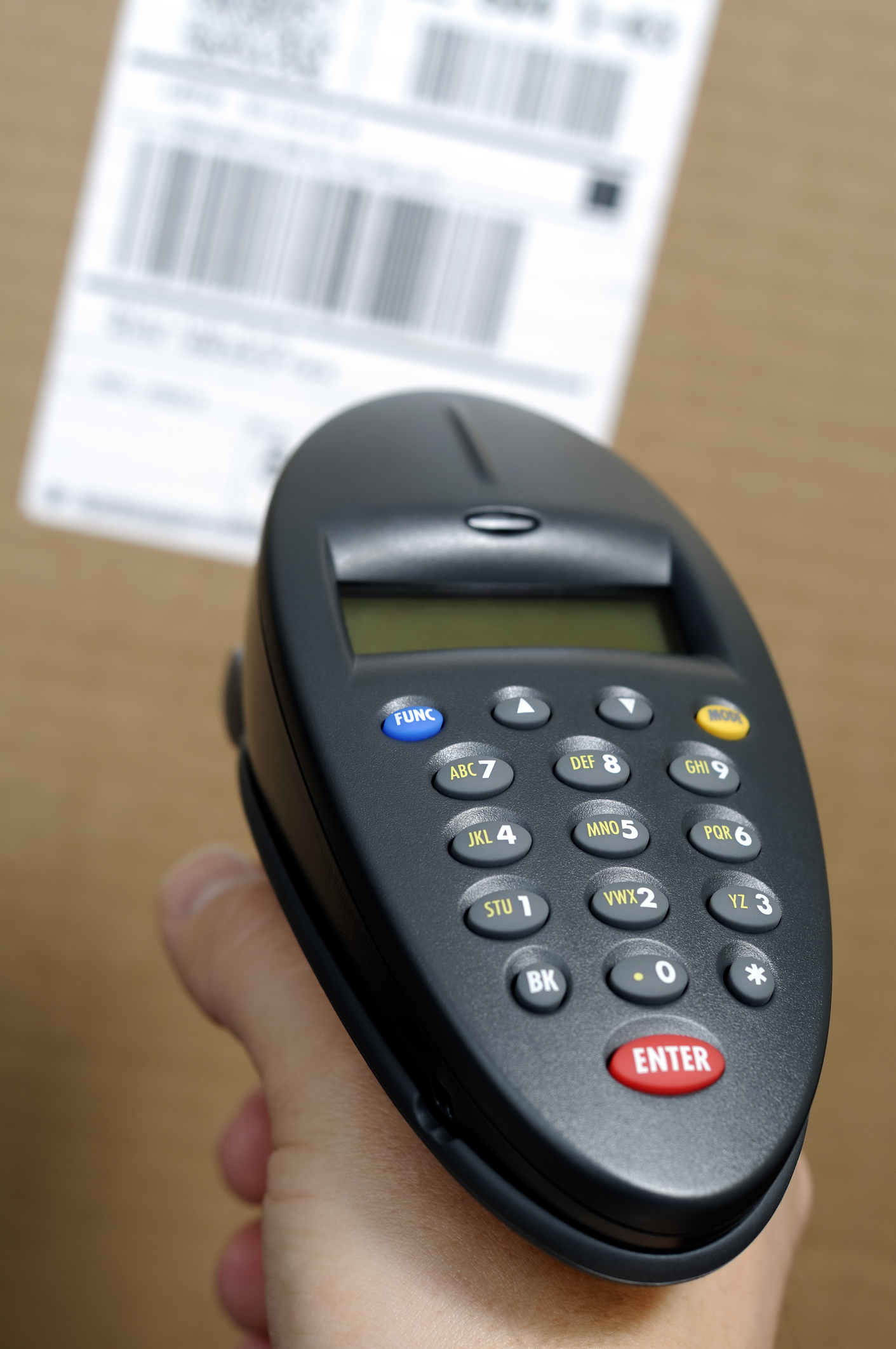 A warehouse employee holding an inventory barcode scanner.
