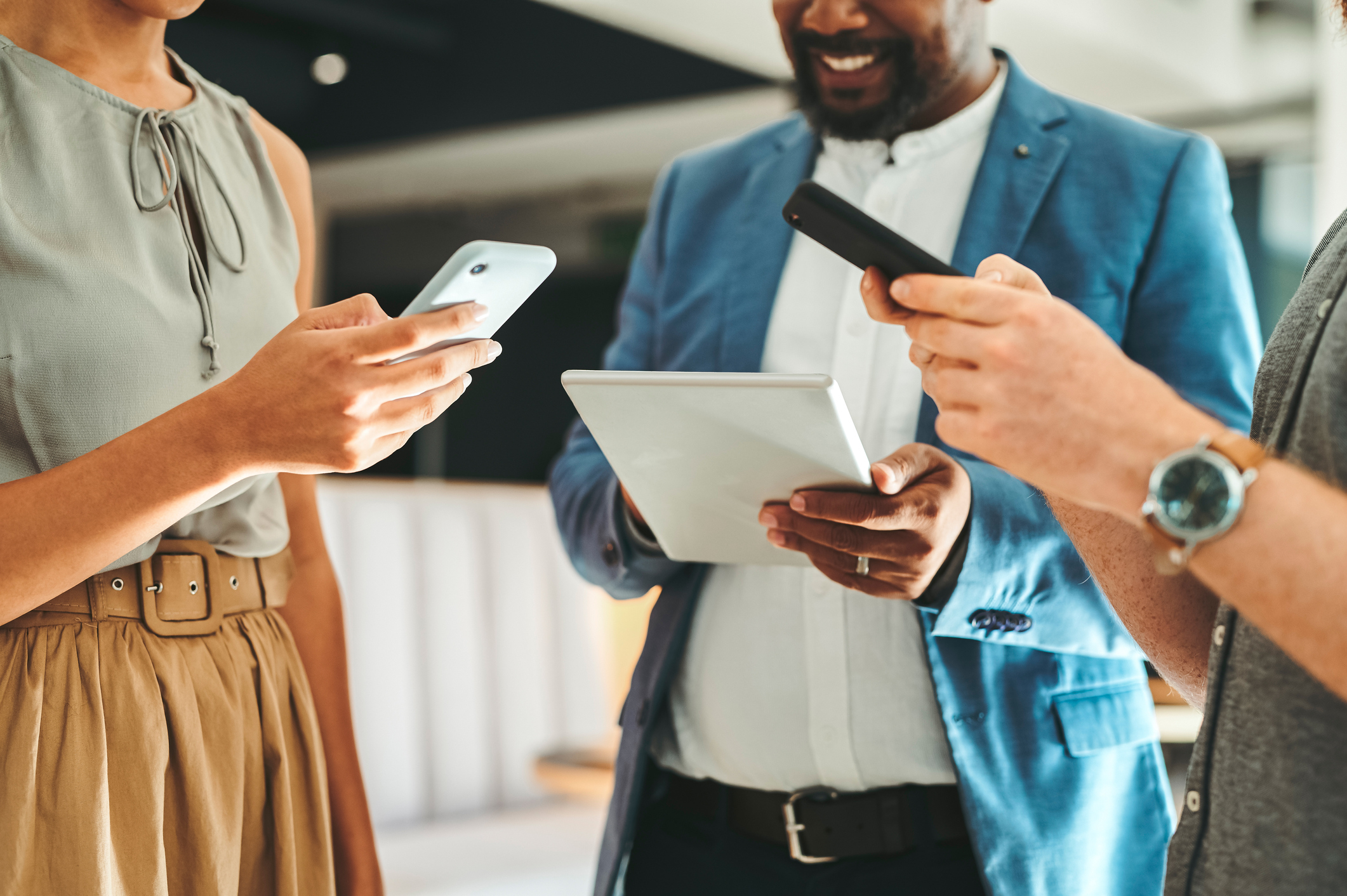 Concept de mobilité représenté par de jeunes professionnels tenant des appareils mobiles dans leurs mains.