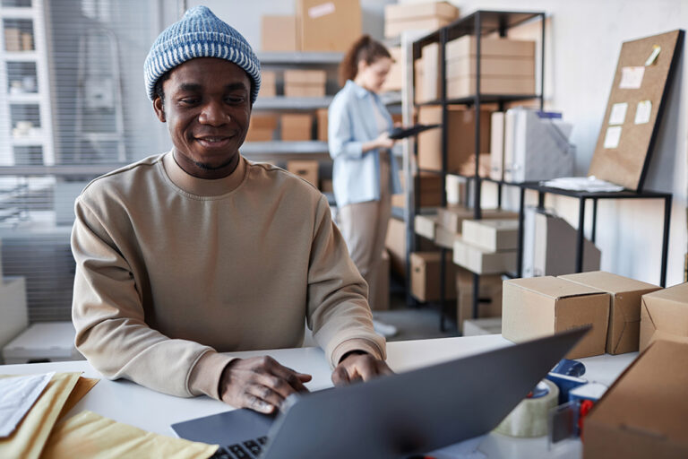 A man working on a laptop in a shipping office.