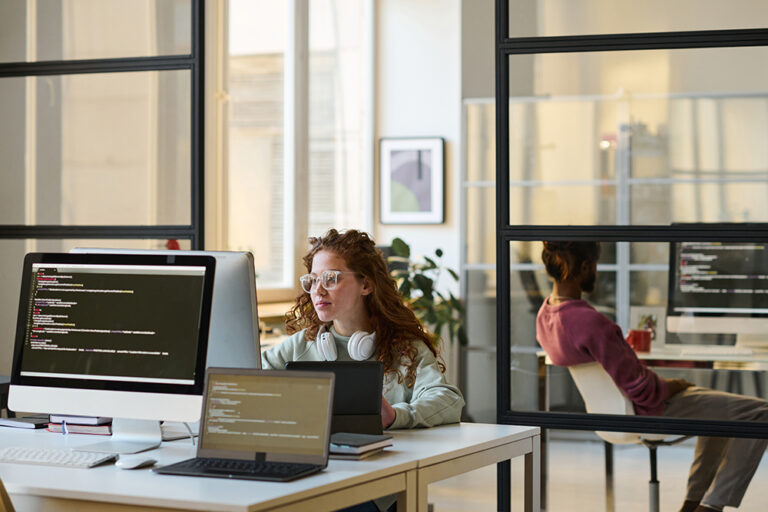 A team working together on computers in a modern IT office.