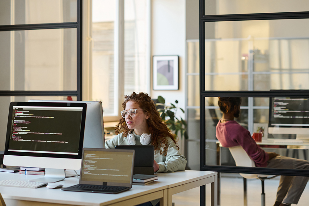 A team working together on computers in a modern IT office.